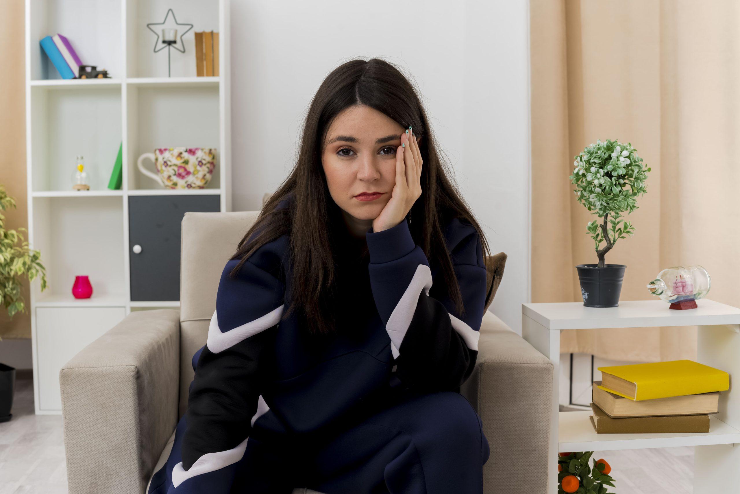 bored-young-pretty-caucasian-woman-sitting-armchair-designed-living-room-keeping-hand-face-looking (1) online adhd treatment for adults
